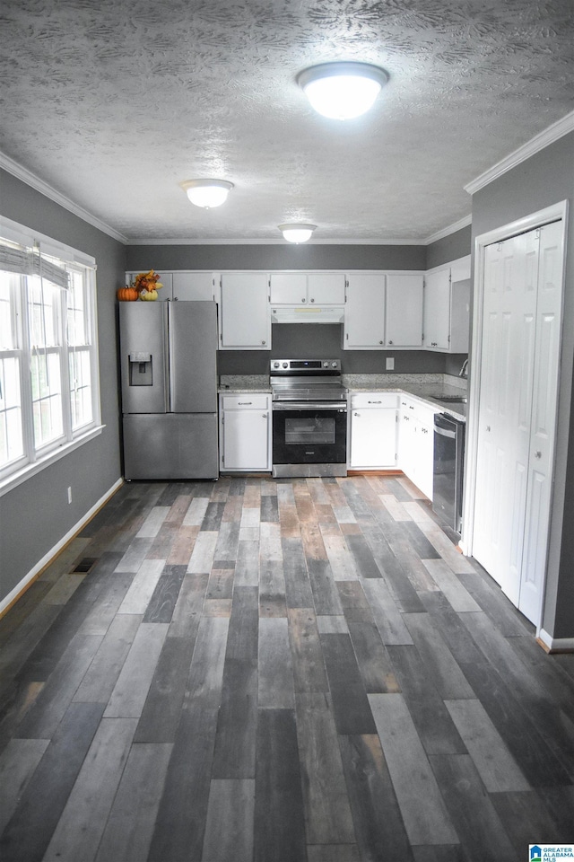 kitchen featuring under cabinet range hood, a textured ceiling, crown molding, and appliances with stainless steel finishes