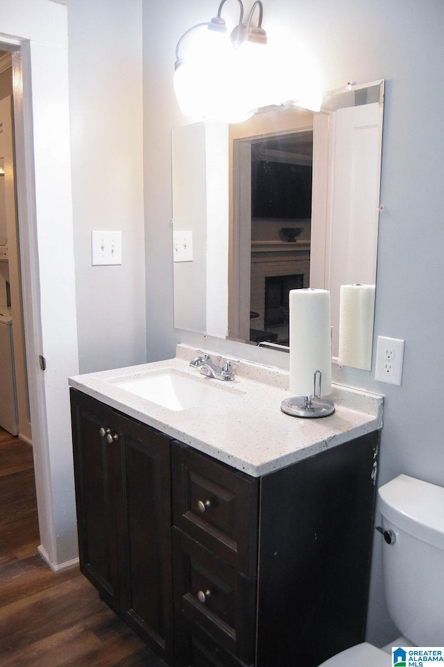 bathroom with vanity, wood finished floors, and toilet