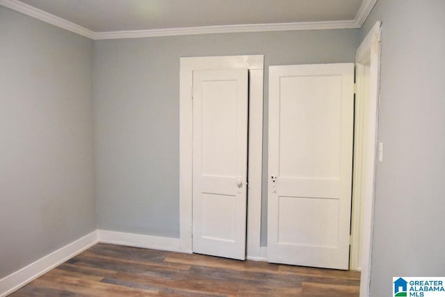 unfurnished bedroom featuring baseboards, ornamental molding, and dark wood-type flooring