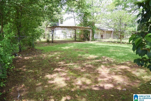 view of yard featuring fence and a detached carport