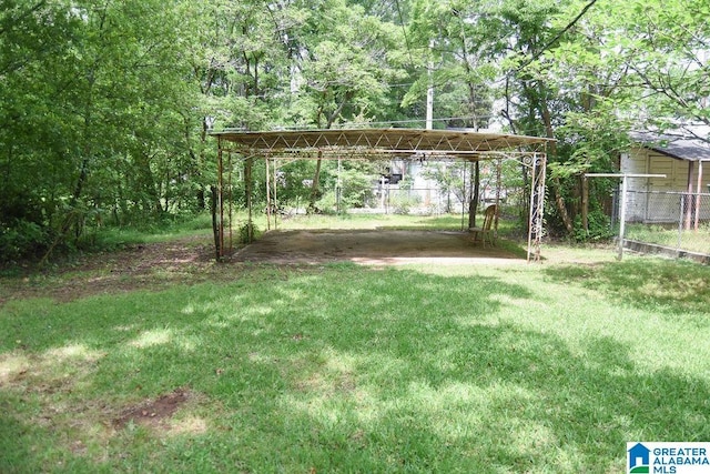 view of yard featuring fence and a carport