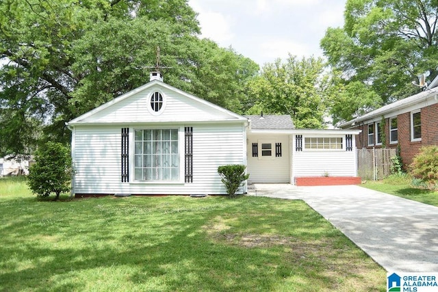 ranch-style house featuring fence, driveway, and a front lawn