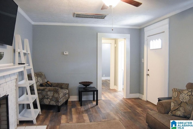 living room featuring visible vents, a ceiling fan, wood finished floors, and ornamental molding