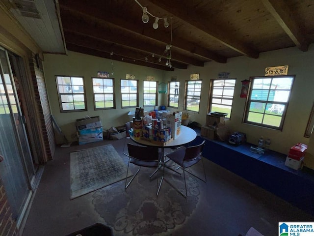 sunroom / solarium featuring beamed ceiling and rail lighting
