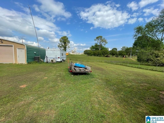 view of yard featuring an outdoor structure and fence