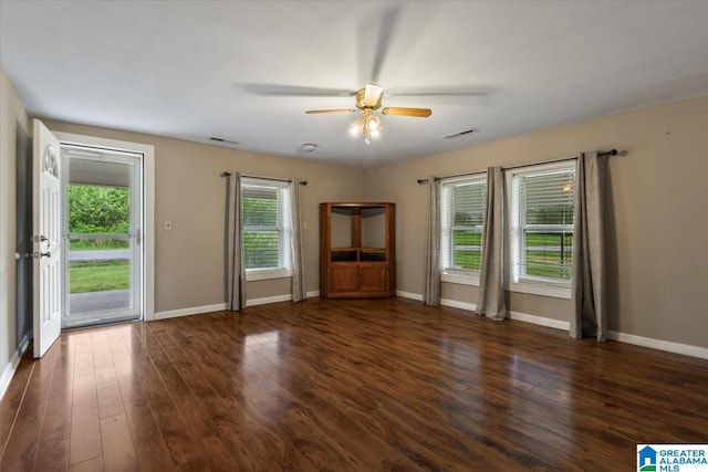 interior space featuring visible vents, baseboards, ceiling fan, and dark wood-style floors