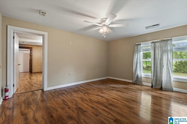 spare room featuring a ceiling fan, baseboards, visible vents, and wood finished floors