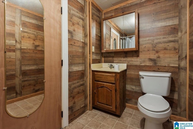 full bath with vanity, wooden walls, and toilet