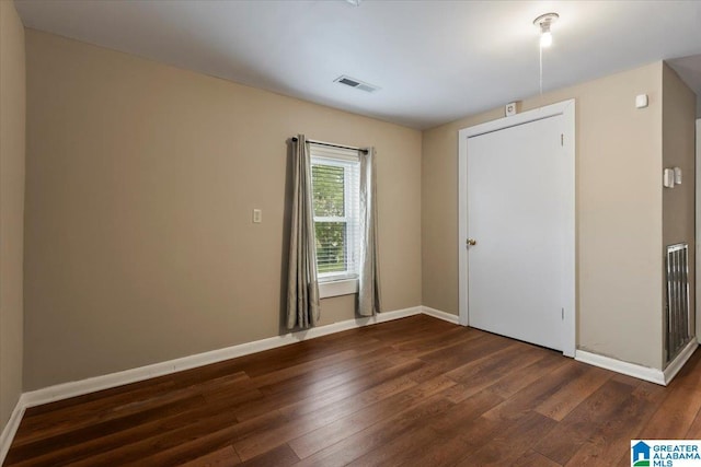 interior space featuring baseboards, dark wood-style floors, and visible vents