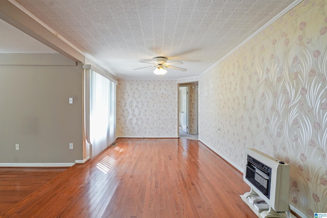 2928 University Way, Centreville, AL 35042 - unfurnished living room featuring ceiling fan, crown molding, baseboards, heating unit, and light wood-style flooring