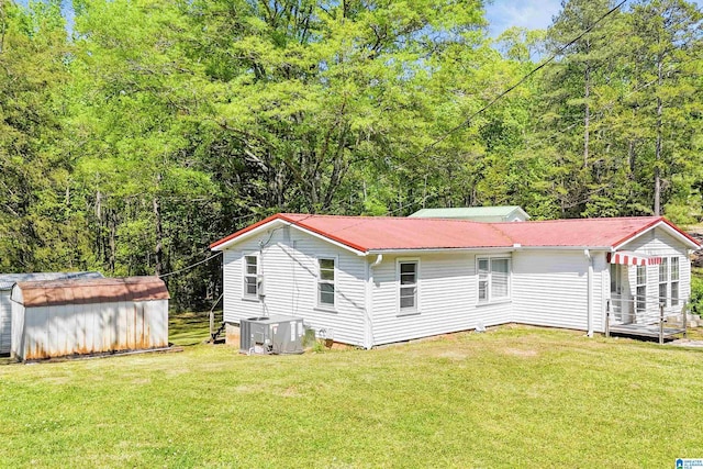 2928 University Way, Centreville, AL 35042 - rear view of property featuring metal roof, a storage shed, an outbuilding, central air condition unit, and a yard