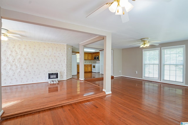 2928 University Way, Centreville, AL 35042 - unfurnished living room featuring heating unit, wood finished floors, baseboards, ceiling fan, and a large fireplace