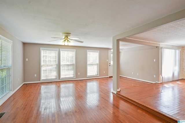 2928 University Way, Centreville, AL 35042 - unfurnished living room with wood-type flooring, a ceiling fan, baseboards, and visible vents
