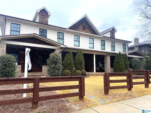 view of front of house featuring a porch and a fenced front yard