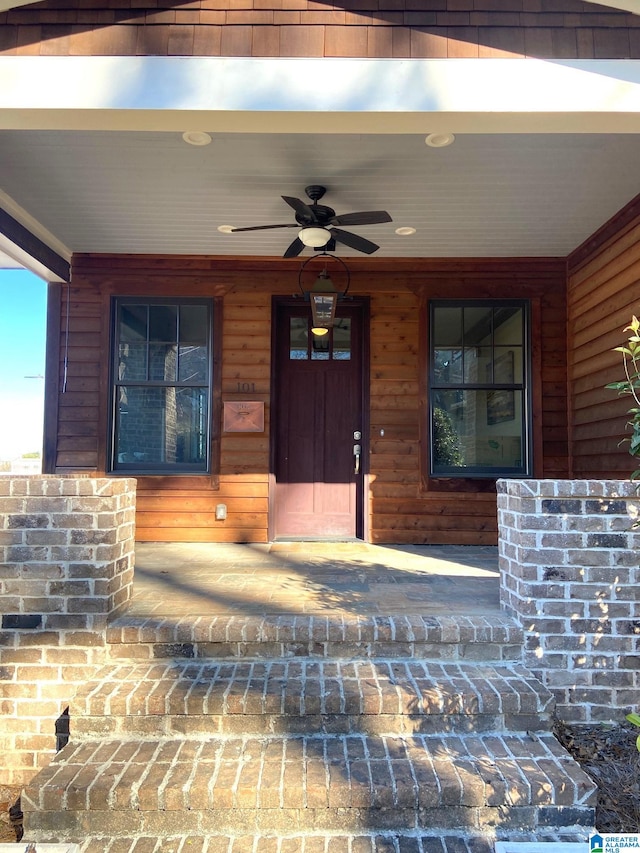 entrance to property featuring a porch and ceiling fan