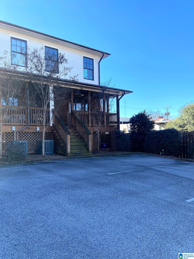view of front facade featuring a porch, stairs, and central air condition unit
