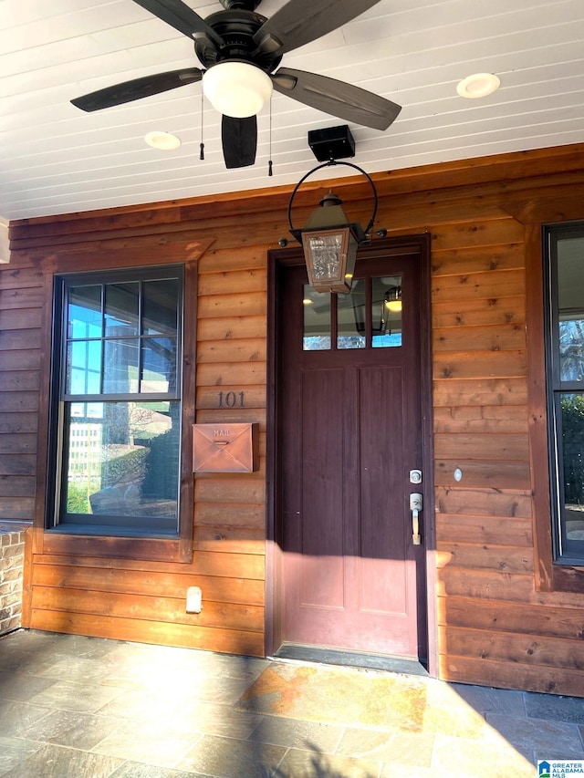 entrance to property with a porch and a ceiling fan