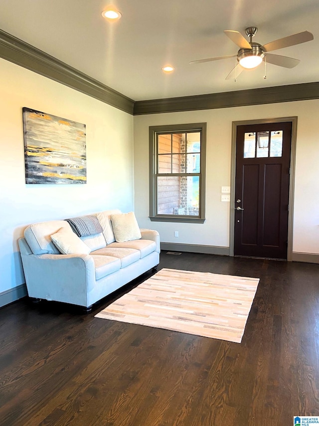 living room with crown molding, a ceiling fan, baseboards, and a healthy amount of sunlight