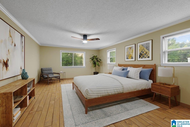 bedroom with a textured ceiling, ornamental molding, a ceiling fan, and light wood-style flooring