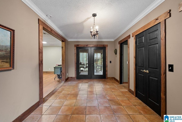 entryway with an inviting chandelier, a textured ceiling, french doors, baseboards, and ornamental molding