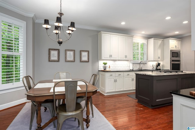 1012 Oak Tree Rd, Hoover, AL 35244 - kitchen with appliances with stainless steel finishes, an inviting chandelier, ornamental molding, tasteful backsplash, and dark wood-style floors