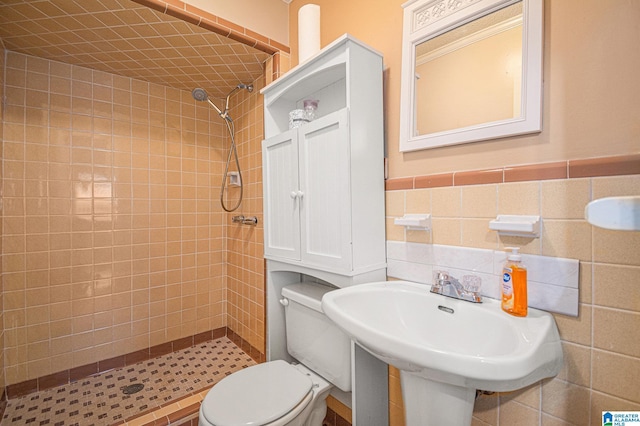 bathroom featuring toilet, a sink, and a stall shower