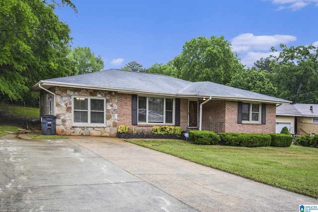 single story home with a front lawn, driveway, and stone siding