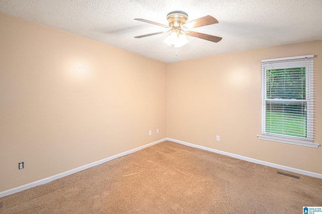 spare room featuring a textured ceiling, ceiling fan, light carpet, and baseboards