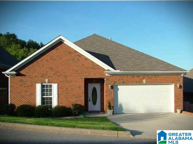 view of front of property with brick siding, a garage, and concrete driveway