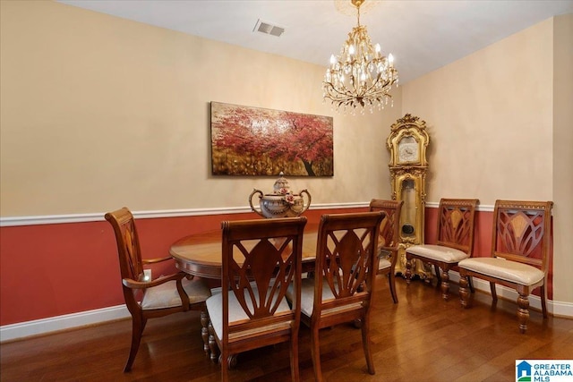 dining area with wood-type flooring, a chandelier, and baseboards