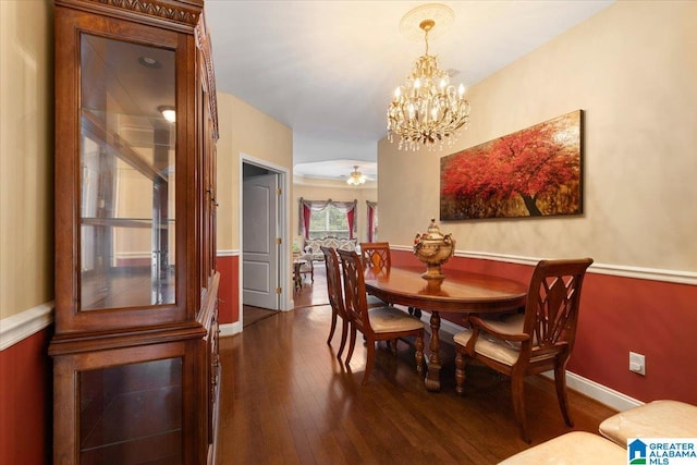 dining area with dark wood-style flooring, a chandelier, and baseboards