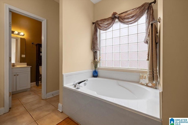 full bathroom featuring vanity, a bath, tile patterned flooring, baseboards, and healthy amount of natural light
