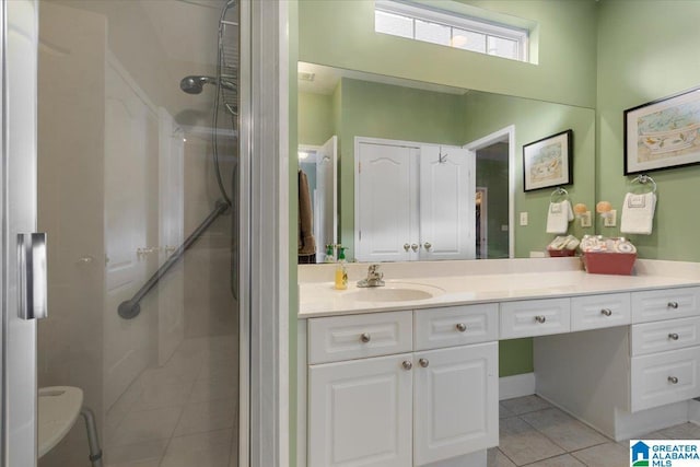 bathroom with tile patterned flooring, vanity, and a shower