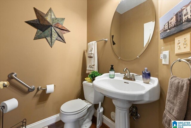 half bath with toilet and baseboards