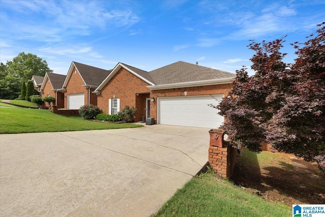 traditional home with concrete driveway, brick siding, an attached garage, a front yard, and a shingled roof