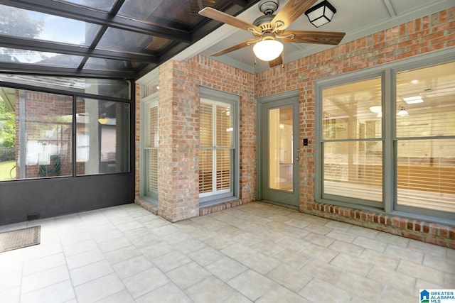 unfurnished sunroom with ceiling fan
