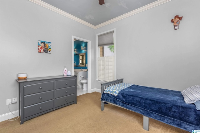 bedroom featuring carpet floors, crown molding, baseboards, ensuite bathroom, and ceiling fan
