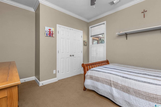 bedroom featuring a closet, ornamental molding, baseboards, a ceiling fan, and carpet