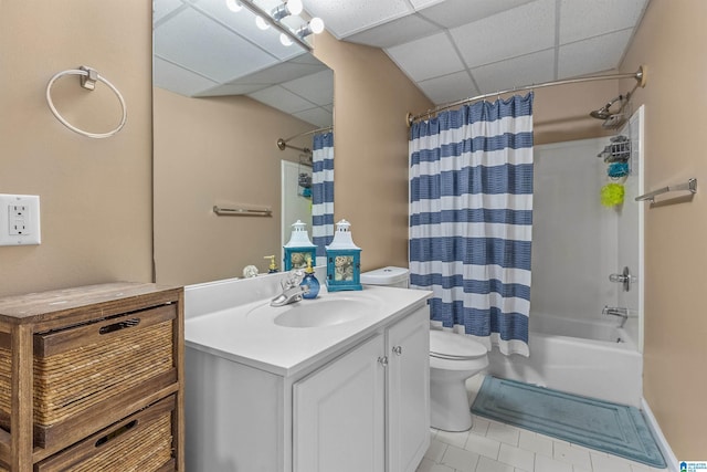 full bathroom with vanity, tile patterned floors, toilet, shower / tub combo with curtain, and a drop ceiling
