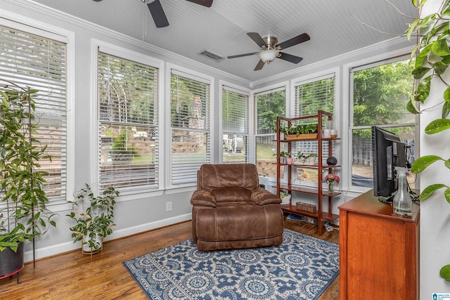sunroom featuring crown molding, baseboards, and a healthy amount of sunlight