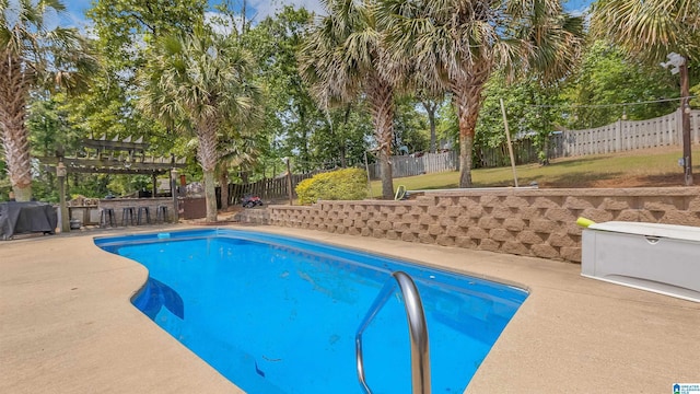 view of pool with a pergola, a fenced backyard, outdoor dry bar, a fenced in pool, and a patio area