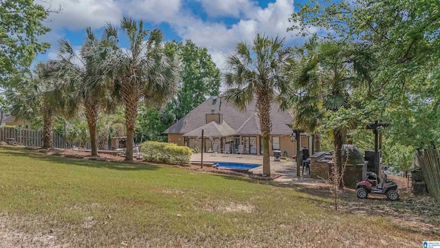 view of yard featuring a patio, an outdoor pool, and fence