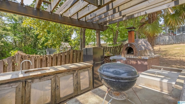 view of patio / terrace with an outdoor fireplace, fence, a pergola, and area for grilling