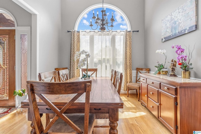dining room featuring light wood-type flooring and a notable chandelier