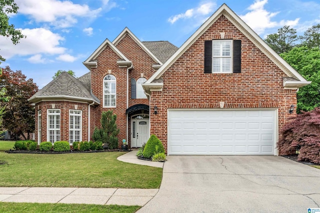 traditional home with concrete driveway, an attached garage, brick siding, and a front yard