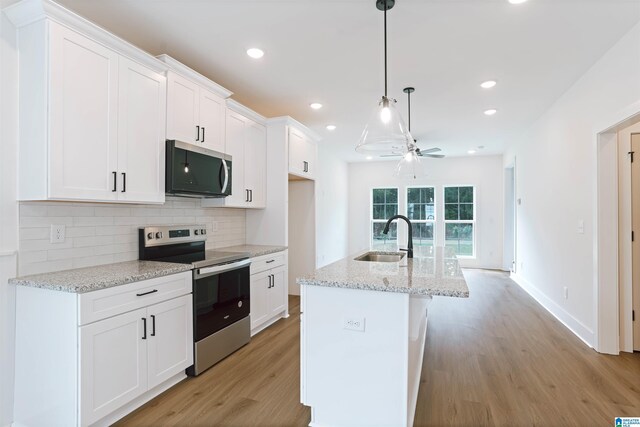 377 Shiloh Creek Dr, Calera, AL 35040 - kitchen with stainless steel appliances, a sink, a ceiling fan, light wood finished floors, and white cabinets