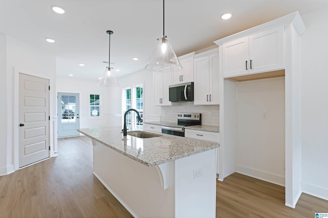377 Shiloh Creek Dr, Calera, AL 35040 - kitchen featuring stainless steel appliances, a sink, a kitchen island with sink, light wood finished floors, and white cabinetry