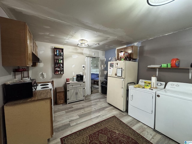 kitchen featuring freestanding refrigerator, under cabinet range hood, light wood finished floors, and washer and clothes dryer