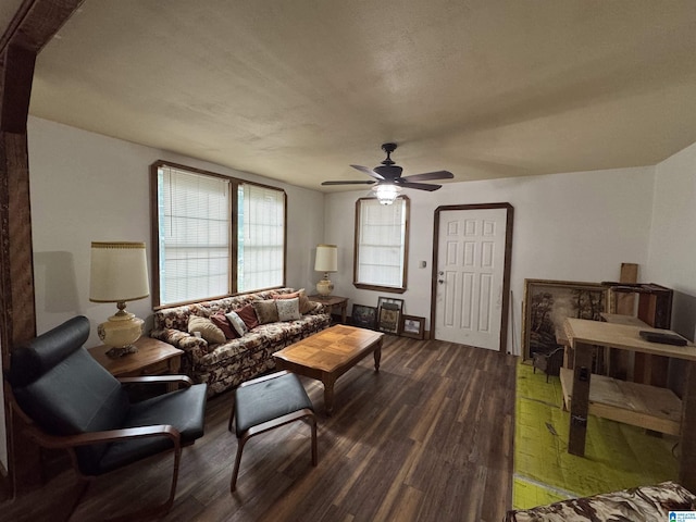 living room featuring a ceiling fan and dark wood finished floors