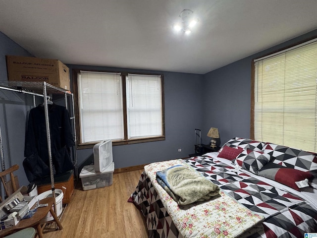 bedroom with baseboards and wood finished floors